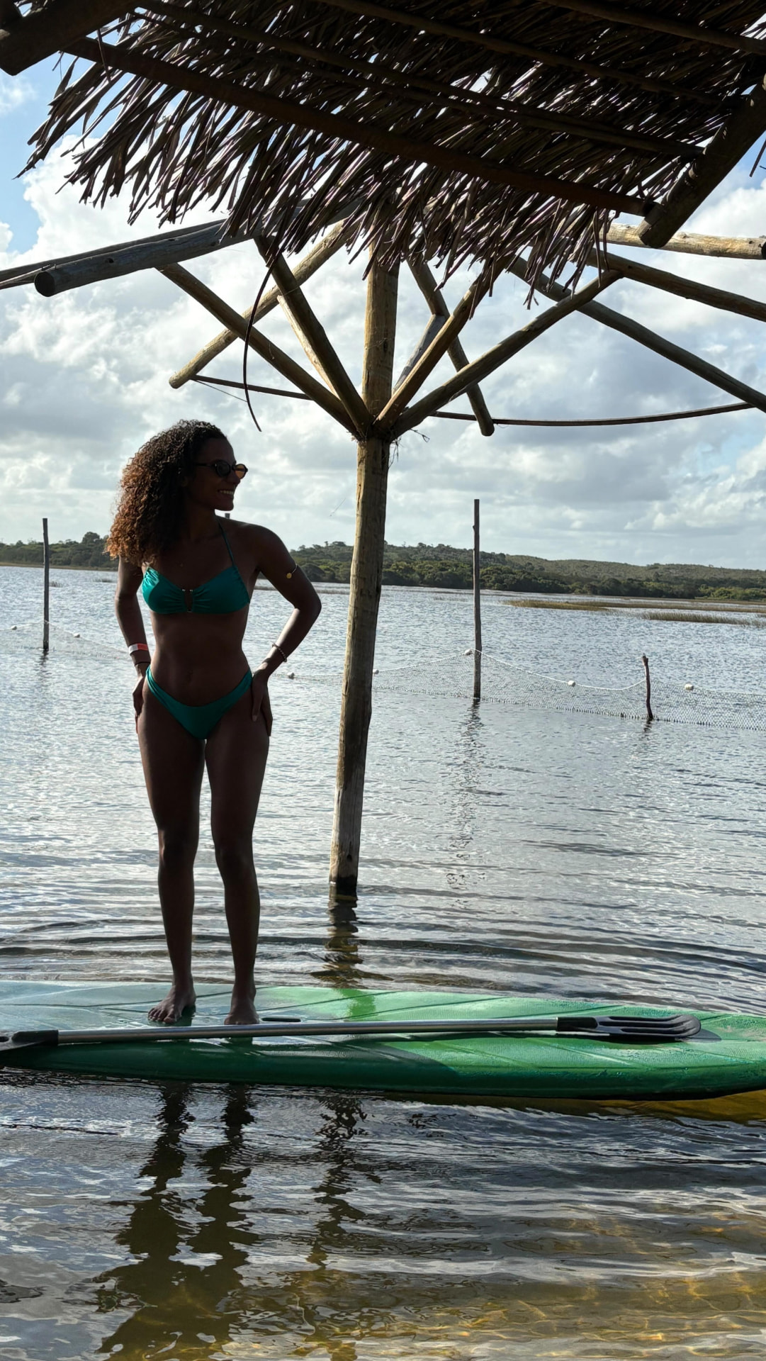 Stand up paddle sob o quiosque de palha nas águas calmas da Lagoa dos Tambaquis, Estância, Sergipe
